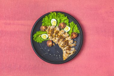 Lezzetli salata, bal ve hardal ayyaş, marul, bıldırcın yumurtası, kiraz domates ve susam siyah seramik kaplama, üstten görünüm, kopya alanı ile tavuk, Hawaii, Asya gıda, mercan tablo, yüzey yaşayan