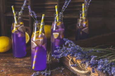 Taze menekşe kokteyl limon, buz ve lavanta, içki şişeleri camına bir karanlık eski rustik tarzı, seçici odak, sığ derinlik-in tarla.