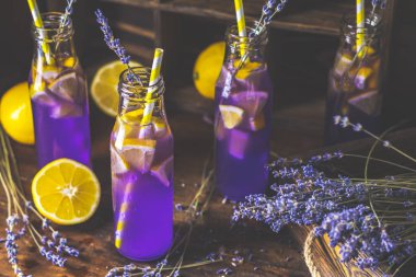 Taze menekşe kokteyl limon, buz ve lavanta, içki şişeleri camına bir karanlık eski rustik tarzı, seçici odak, sığ derinlik-in tarla.