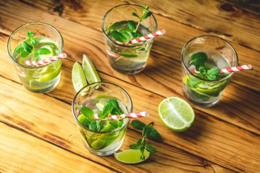 Taze alkollü kokteyl limon, buz ve nane, mojito bur bir rustik masa, seçici odak, sığ derinlik-in tarla içinde kokteyl ile.