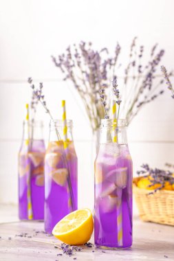 Taze lavanta menekşe kokteyl limon ve buz, içki şişeleri camına bir ışık eski rustik tarzı, seçici odak, sığ derinlik-in tarla.