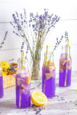 Taze lavanta menekşe kokteyl limon ve buz, içki şişeleri camına bir ışık eski rustik tarzı, seçici odak, sığ derinlik-in tarla.