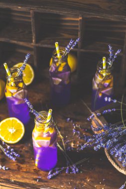 Taze menekşe kokteyl limon, buz ve lavanta, içki şişeleri camına bir karanlık eski rustik tarzı, seçici odak, sığ derinlik-in tarla.