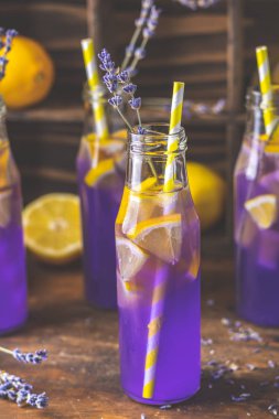 Taze menekşe kokteyl limon, buz ve lavanta, içki şişeleri camına bir karanlık eski rustik tarzı, seçici odak, sığ derinlik-in tarla.