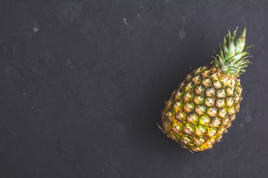 Ananas siyah taş beton yüzey arka plan dokulu. Metniniz için kopya alanı ile üstten görünüm.