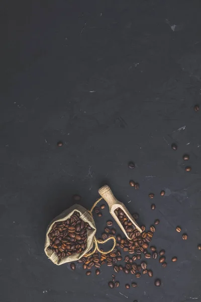 豆の焙煎と黒い石コンクリートの木製スコップ財布テクスチャ表面の背景です テキストのコピー スペースのトップ ビュー — ストック写真