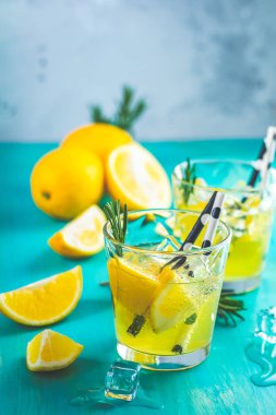 Limon alkol içki kokteyl buz, limon ve biberiye bitki mavi turkuaz ahşap masa arka plan yüzeyi ile. Geleneksel İtalyan ev yapımı limon alkol içki likör limoncello.