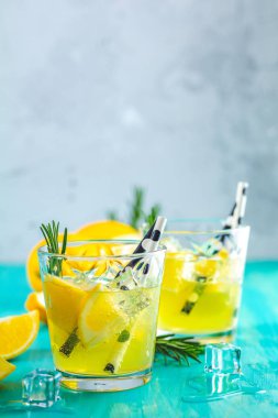 Limon alkol içki kokteyl buz, limon ve biberiye bitki mavi turkuaz ahşap masa arka plan yüzeyi ile. Geleneksel İtalyan ev yapımı limon alkol içki likör limoncello.