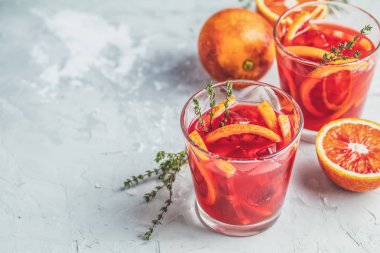 Campari ya da alkol Sicilya kan dilimlenmiş portakal ve ışık gri beton zemin üzerine, kopya baharat, sığ derinlik-in tarla taze kırmızı portakal suyu kokteyli.