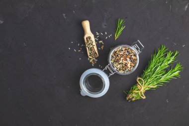 Siyah, mor ve beyaz pirinç (Oryza sativa) cam dokulu kavanoz siyah taş beton yüzey arka planda karıştırın. Metniniz için kopya alanı ile üstten görünüm.