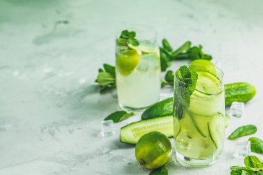 Nane, salatalık ve limon ve mojito kireç ve highball gözlük gri Beton taş yüzey zemin üzerine nane ile kokteyl kokteyl detoks. Metniniz için kopya alanı ile