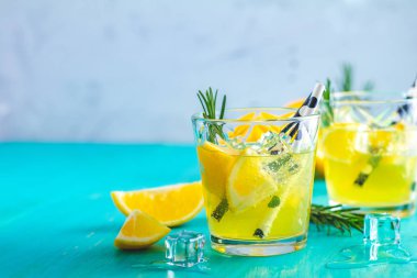 Limon alkol içki kokteyl buz, limon ve biberiye bitki mavi turkuaz ahşap masa arka plan yüzeyi ile. Geleneksel İtalyan ev yapımı limon alkol içki likör limoncello.