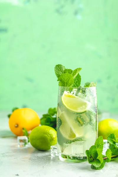 stock image Mojito cocktail with lime and mint in highball glass on a gray and green concrete stone surface background. With copy space for your text