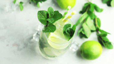 Mojito kireç ve highball cam bir gri ve Yeşil Beton taş yüzey zemin üzerine nane kokteyli. Yakın çekim, sığ derinlik-in tarla 59.94 fps.