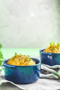 Fırında patates cocotte mavi yeşil soğan ve peynir ile seramik pişirme kalıpları içinde lezzetli bölümü. Yemek yemek için. Görünümü kapatın.