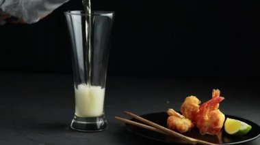 Kızarmış karides tempura siyah plaka kireç ve cam pembe ya da şeftali beton yüzey zemin üzerine dökerek bira. Japon ya da Doğu Asya tarzı görev alan deniz ürünleri tempura çanak kopyalama