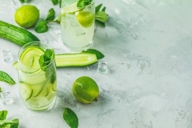 Nane, salatalık ve limon ve mojito kireç ve highball gözlük gri Beton taş yüzey zemin üzerine nane ile kokteyl kokteyl detoks. Metniniz için kopya alanı ile