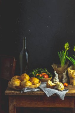 Mutlu Paskalya kartpostal ahşap plaka ayakta çiğdemler çiçekler ve keten masa örtüsü üzerinde tavşan dekor ev yapımı buns ile. Kopya alanı, karanlık rustik tarzı.