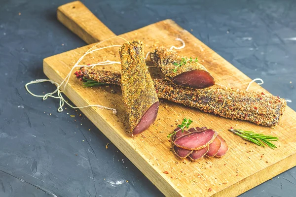 Sarsıntılı, basturma, kurutulmuş Dana eti, et Füme pastırma ile baharat ahşap kesme tahtası üzerinde yakın çekim.