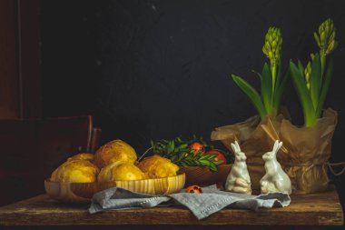 Mutlu Paskalya kartpostal ahşap plaka ayakta çiğdemler çiçekler ve keten masa örtüsü üzerinde tavşan dekor ev yapımı buns ile. Kopya alanı, karanlık rustik tarzı.