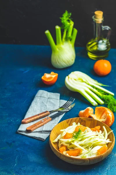 Fennel and orange citrus salad on wooden plate between ingredien