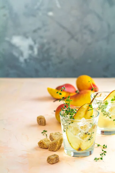 Cold pear white tea with thyme on the pink concrete table — Stock fotografie