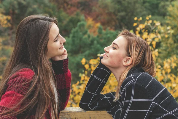 Duas lindas e bonitas jovens mulheres conversando no parque — Fotografia de Stock