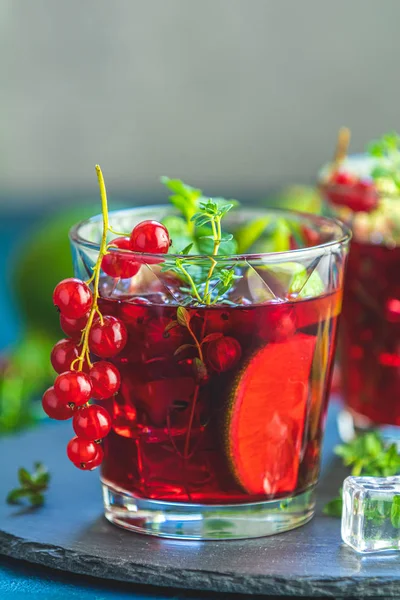 Cold red cocktail in glass with currant