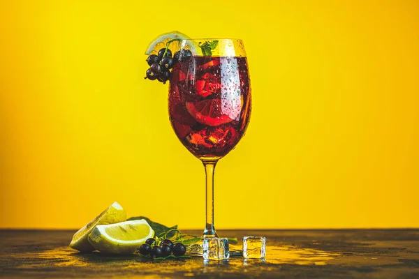 Cocktail com groselha preta no fundo amarelo — Fotografia de Stock