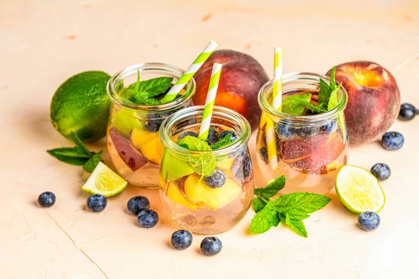 Blaubeeren und Pfirsiche enthalten Wasser, Cocktail, Limonade oder Tee. su — Stockfoto
