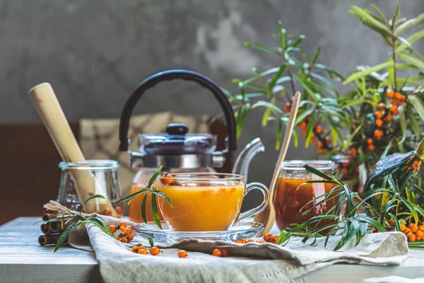 Hete pittige thee met duindoorn in glazen beker en theepot, selecteer — Stockfoto