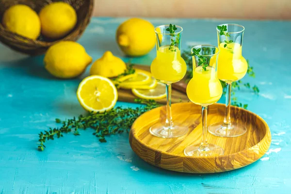 Tahta tepside üç grappas şarap kadehinde kekikli limoncello.,