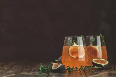 Koyu ahşap ba cam incir, kekik ve buz ile Pembe kokteyl