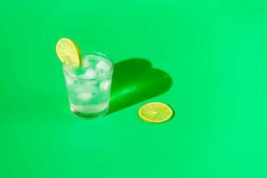 Taze Mojito kokteyli, limonlu ve buzlu, parlak güneş ışığında yeşil arka planda su damlaları, Mojito ferahlatıcı içecekler. Kopyalama alanı, yaz tatili ve parti konsepti