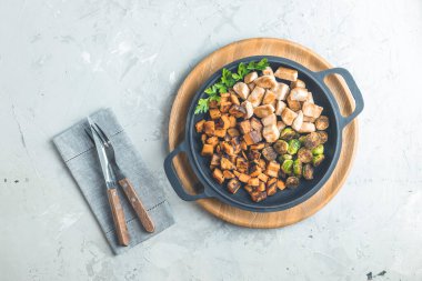 Sağlıklı yiyecekler. Bir kap tavuk eti, kızarmış patates ve Brüksel lahanası. Üst manzara, açık gri beton yüzey, düz uzanma.