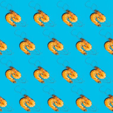 Mavi arka planda karideslerin köşegen şeklindeki yiyecekleri. Yaratıcı minimalist daire sert ışıkla yatıyordu.