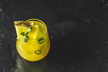 Baharatlı ananas jalapeno mezcalita veya Cinco de Mayo için margarita, siyah yüzey üzerinde ananas, kişniş, jalapeno ve Meksika damıtılmış alkollü içecekten yapılan ferahlatıcı bir kokteyl.