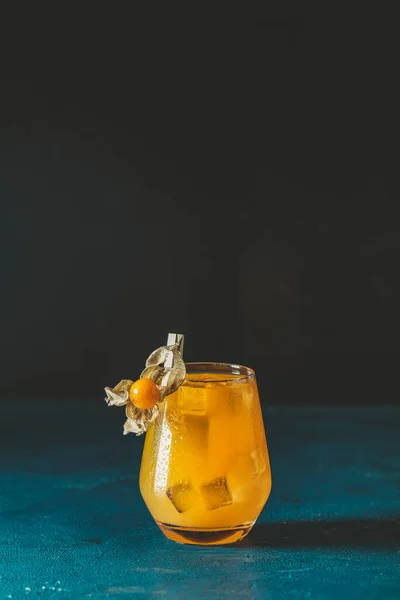 黄橙鸡尾酒配以橘子和迷迭香 配以水滴装饰的黄花和深色底色的红糖 圣诞及新年佳节欢迎酒 — 图库照片