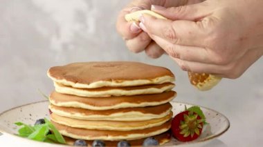 Kadınlar krep ve süsleme için el çırpıyor taze çiğ çilek.