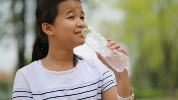 asian teenager drinking fresh water from plastic bottle