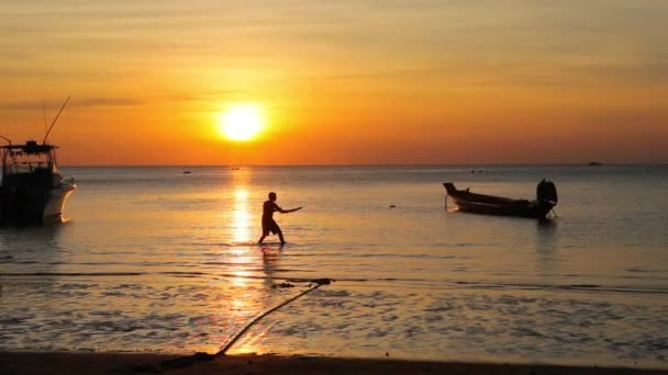 男人在沙滩上迎着美丽的夕阳西下玩飞碟 — 图库视频影像