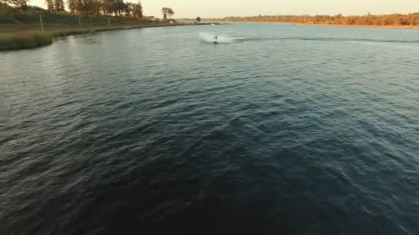 平野の湖でジェットスキーをする男の空中ビュー — ストック動画