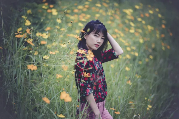 アジアの若い女性モデルのポートレート黄色い花の咲くフィールドでポーズを取る — ストック写真