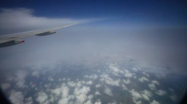 Uçak kanadı yağmur bulutları arasında uçuyor. 