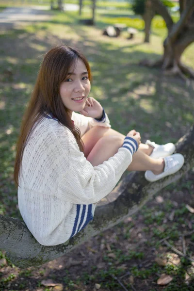 公園でリラックスしたアジアの若い女性のこぼれるような笑みを浮かべて顔幸福感情 — ストック写真