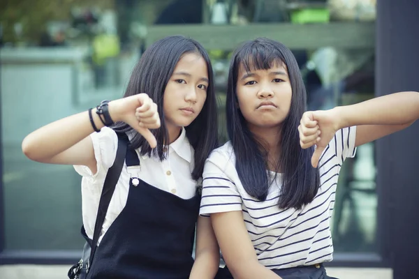 Two asian teenager hand sign thumb no good with not satisfy face — Stock Photo, Image