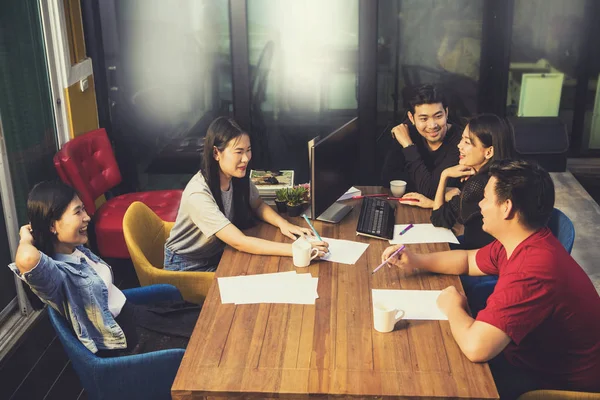 Più giovane asiatica freelance team rilassante sul tavolo di lavoro in ufficio — Foto Stock