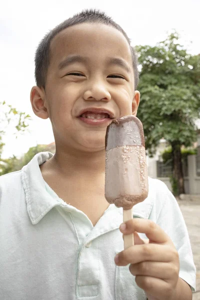 Close up face of asian boy eating chocolate icecream with happin — Stock Photo, Image