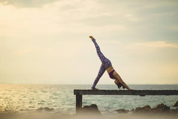 Kadın Oyun Yoga Poz Beach Iskelesinden Sabah Işık Ile Üzerinde — Stok fotoğraf