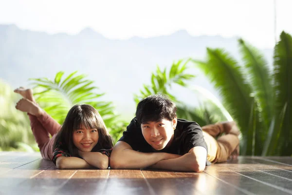 年轻的亚洲男人和女人躺在家里的木地板上幸福的脸夫妇 — 图库照片